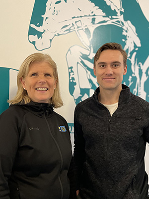 Woman and a man in front od a wall painting
