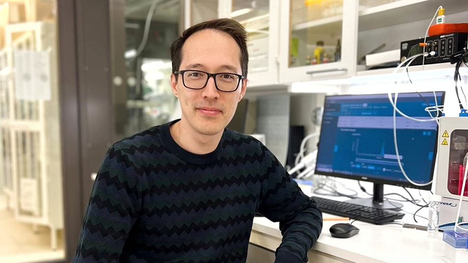 Man stående framför buske.