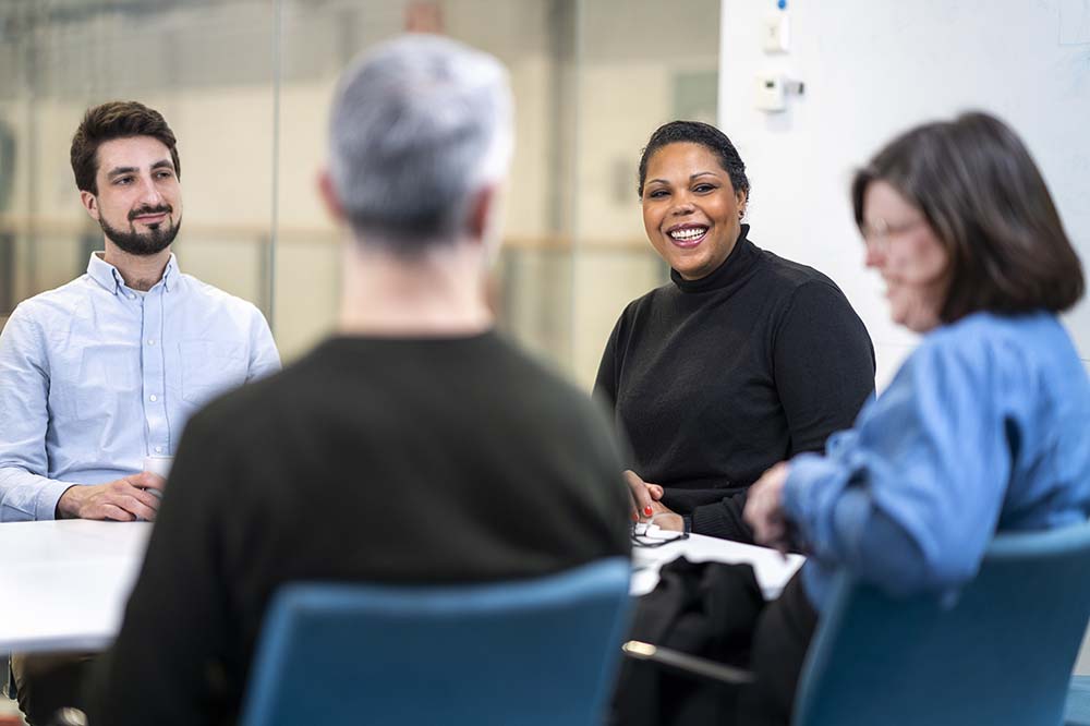 Four course participants looking at each other and smiling