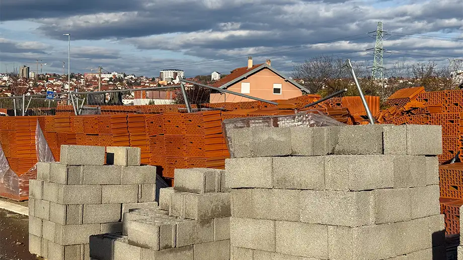 a stack of concrete slabs in the foreground, houses in the background