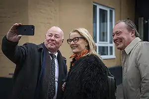 Two men and a woman taking a selfie.