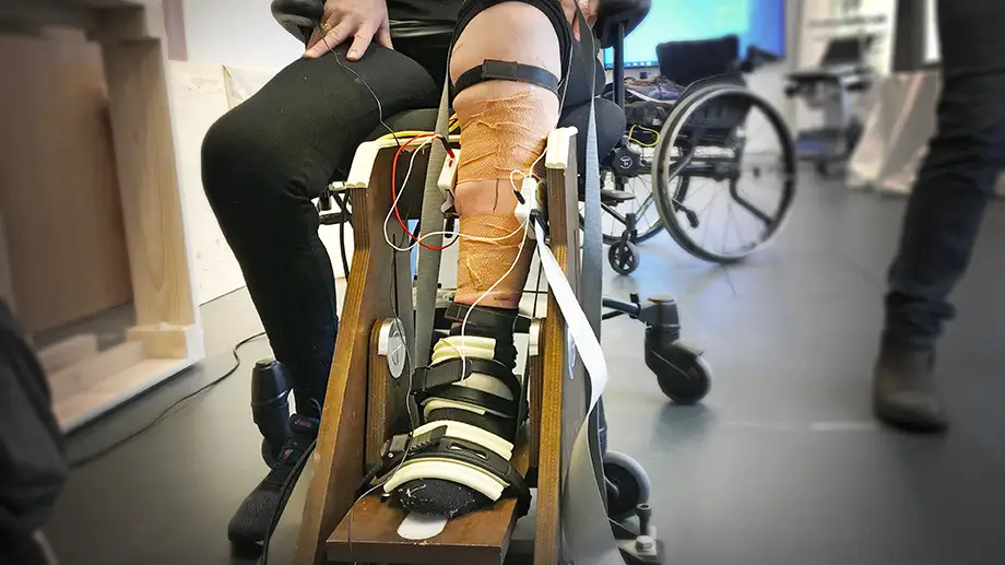 Person in wheelchair stepping on device that measures force.