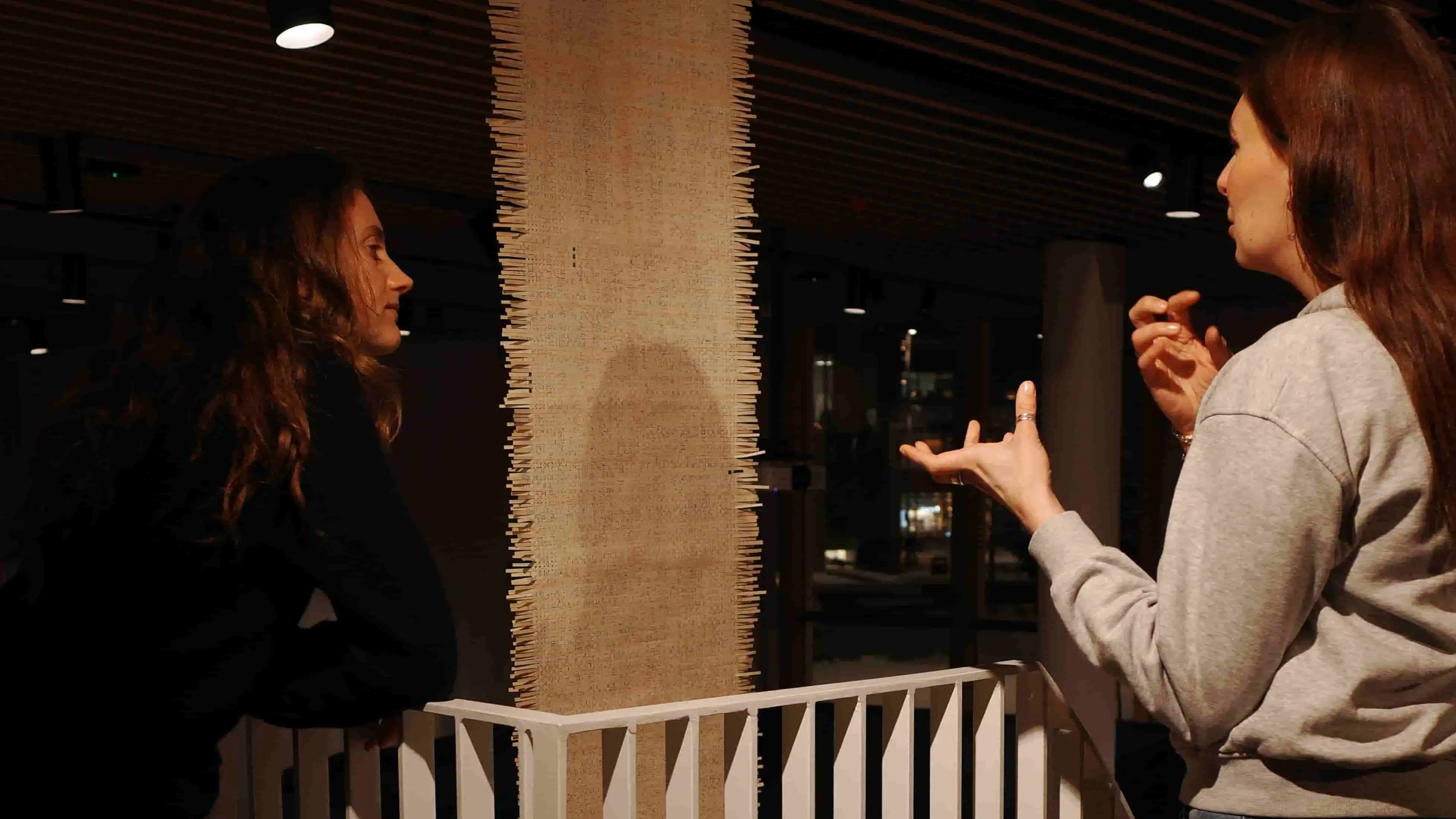 Joanna talking to a visitor in front of her tapestry. Photo: Helena Linder