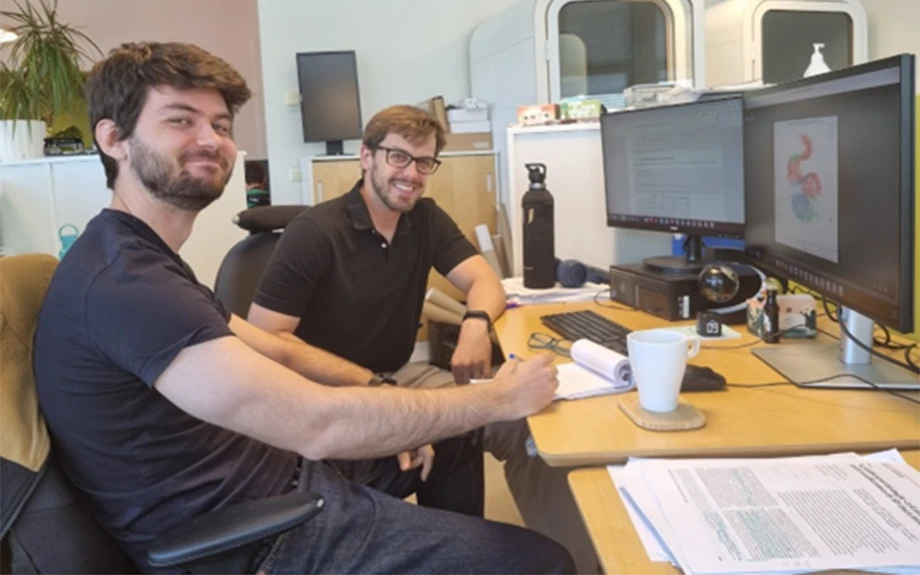 Two men sitting at a desk. 