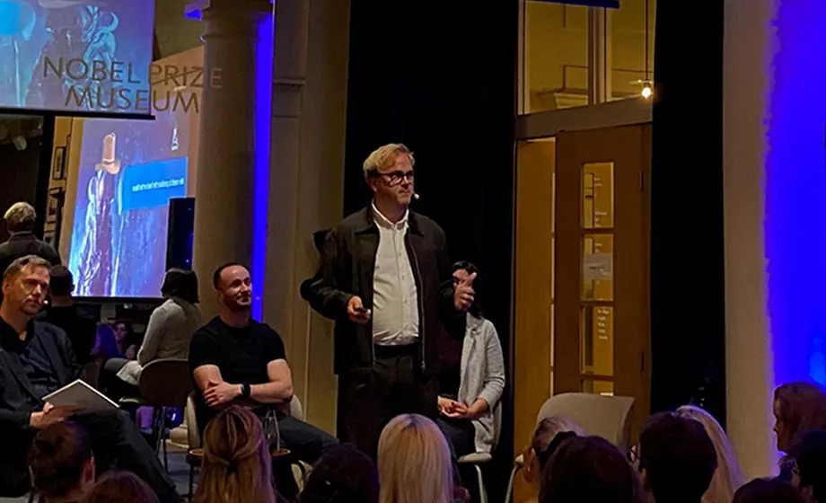 Man giving a lecture in front of an audience.