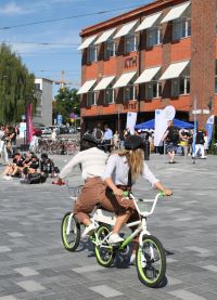Två studenter på en tandemtrehjuling där ena studenten sitter baklänges