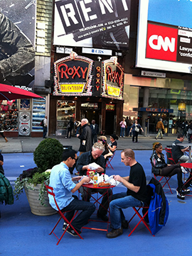 People sitting and eating on the street in New York.