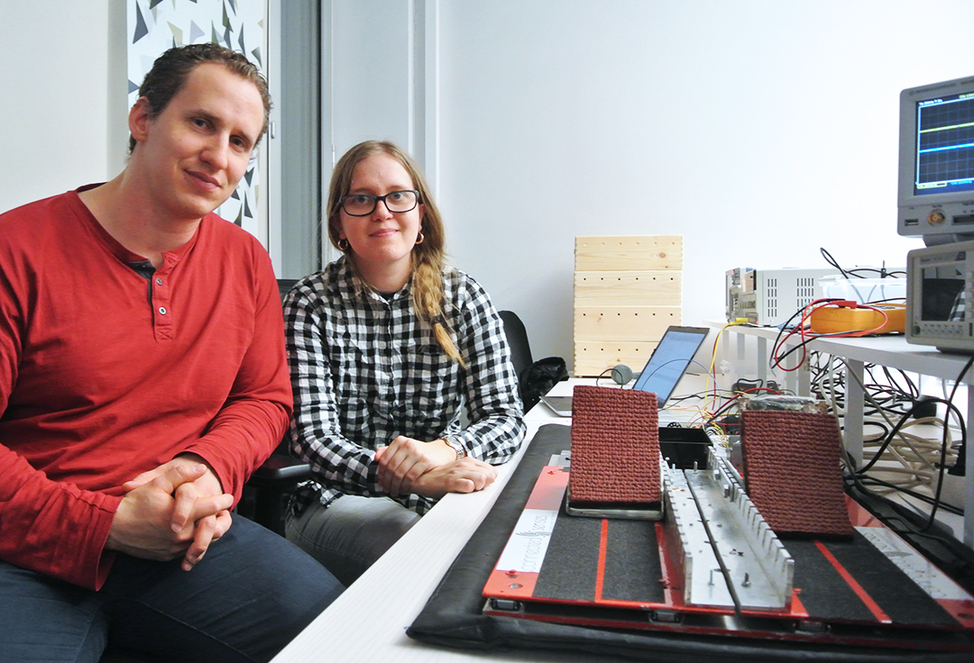 Two students are showing their degree project, a starting-block used in track and field.