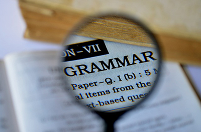 A magnifying glass magnifies the word grammar 