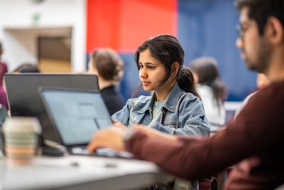 A woman sits in front of a computer.