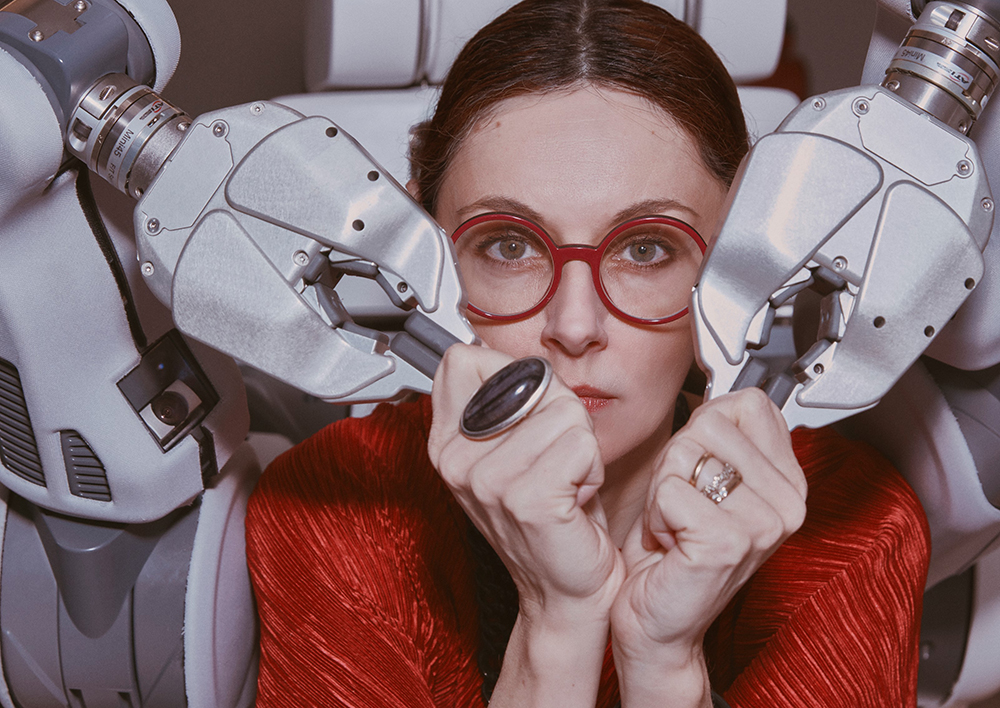 Forskaren Danica Kragic omgärdad av en robot vars händer hon håller i.