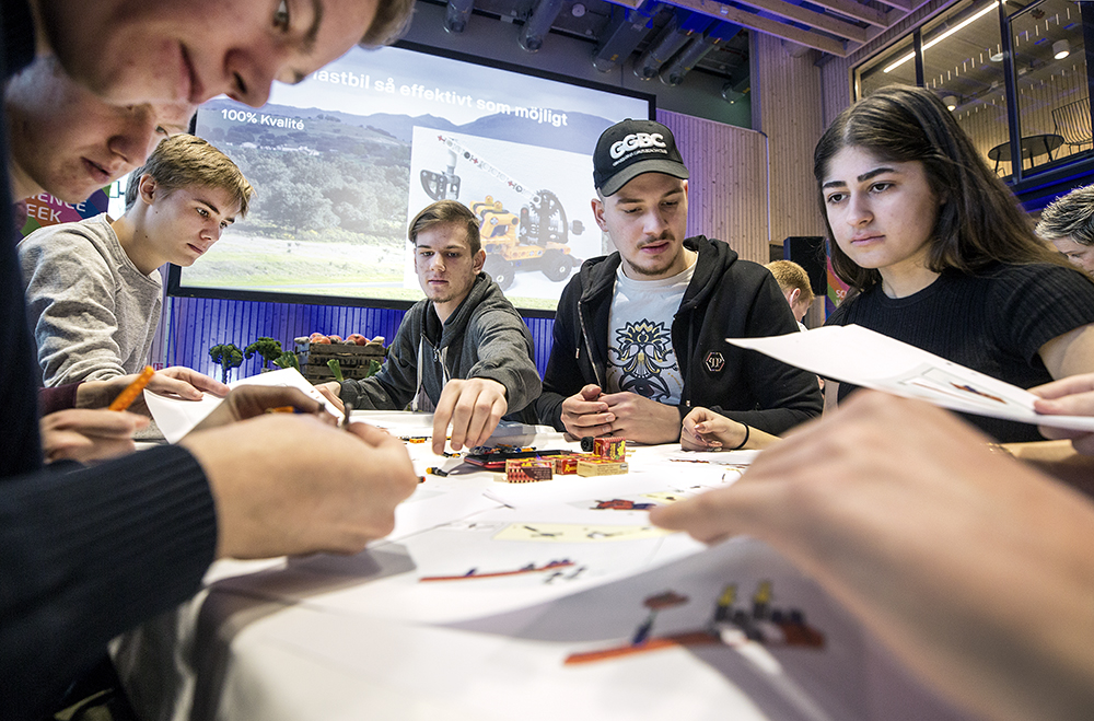 Bilden visar några elever från Tumba gymnasium som bygger en legomodell av en lastbil.