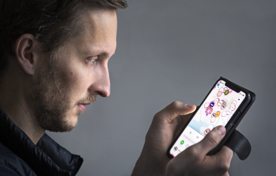 Ludvig Berling tittar på Karmas app i sin mobil.