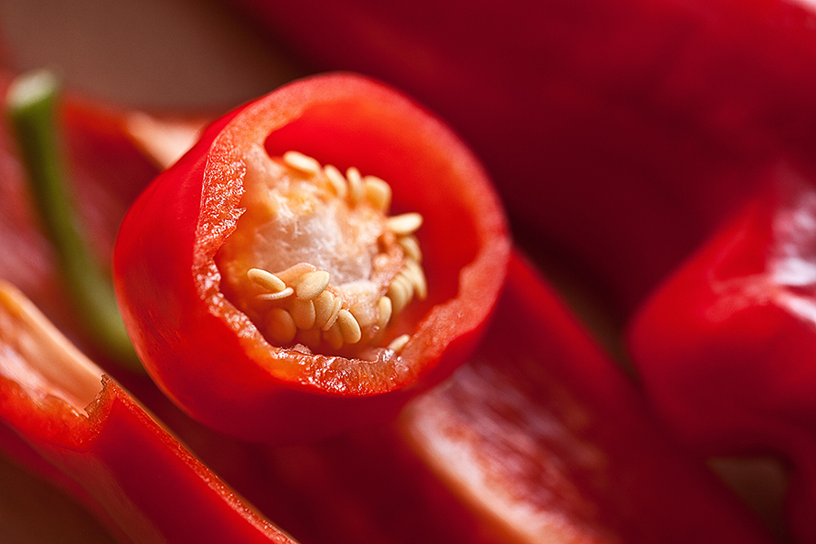 En röd chilifrukt som är delad så att man ser chilins innanmäte med frön.