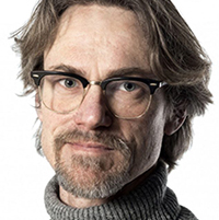 Porträttfoto av David Nilsson, föreståndare för KTH Vattencentrum. Han bär glasögon och en stickad polotröja.