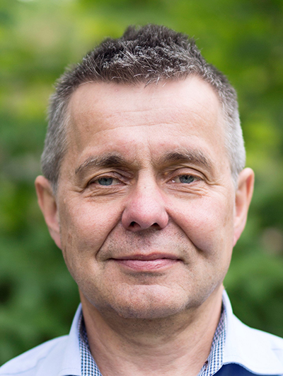 KTH-professorn Lennart Söder porträttfotograferad. Har ett litet, snett leende. 