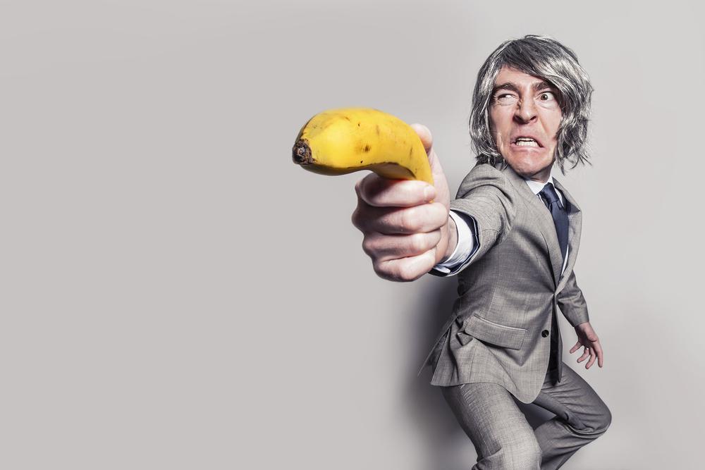 Humorous image with a man holding a banana like a gun