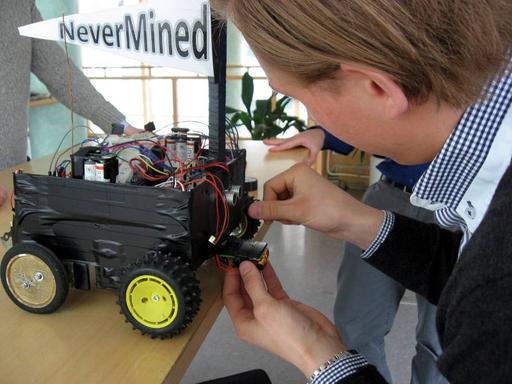 Team Huskvarna justerar roboten NeverMined inför utställningen.